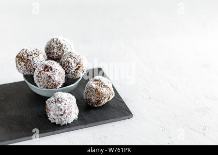 Hausgemachte Energie Kugeln mit Kokos. Gesunde Lebensmittel für Kinder und vegan, Süßigkeiten ersetzen. Gesunde bio Energie Kugeln mit Datteln, Backpflaumen, rais Stockfoto