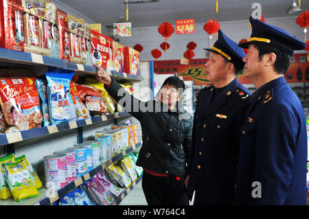 ------ Chinesische Polizeibeamte prüfen die Qualität der Milchprodukte in einem Supermarkt in Zouping County, Binzhou, East China Shandong p Stockfoto