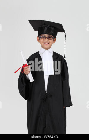 Junge im Abschluss Kleid mit einem Abschluss Stockfoto