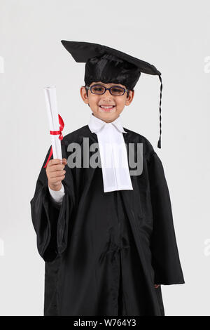 Junge im Abschluss Kleid mit einem Abschluss Stockfoto