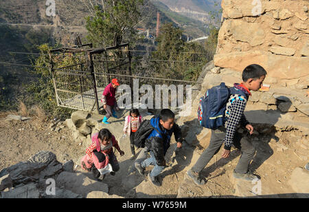 Lokale chinesische Kinder kommen auf ihrem Weg von der Schule nach Hause, nachdem Sie mit einer Luftseilbahn eine Fahrt in einem stahlkäfig Li Reisen zu nehmen Stockfoto