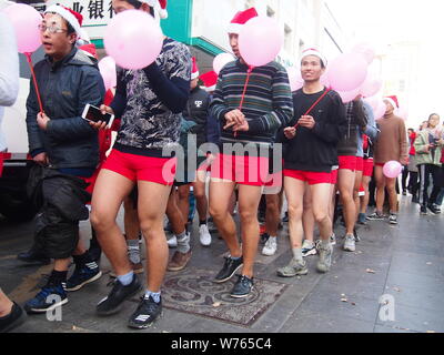 Spärlich bekleideten Menschen während einer Parade Weihnachten Santa Undie Run auf einer Straße in Ji'nan Stadt feiern, der ostchinesischen Provinz Shandong, 24. Dezember 2017 Stockfoto