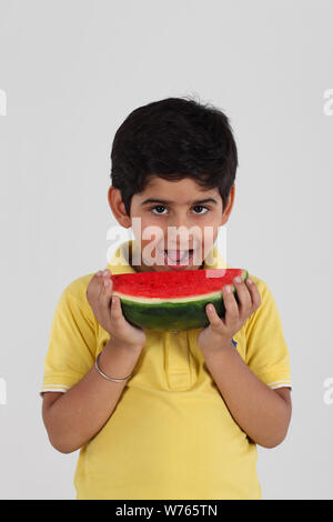 Junge, der eine Wassermelone isst Stockfoto