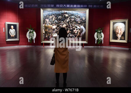 Ein Besucher nimmt Fotos der Öl Gemälde "Nanjing Massaker" von uns - auf der Grundlage der chinesische Künstler Li Zijian auf Chinas Vierter Nationaler Gedenktag für Nanjing Stockfoto