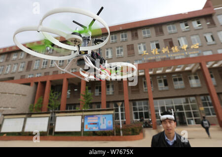 ------ Student Fernbedienung steuert ein UAV (Unmanned Aerial Vehicle) oder Drohne, auf dem Campus der Kunming Universität für Wissenschaft und Technologie in Kunming Stockfoto