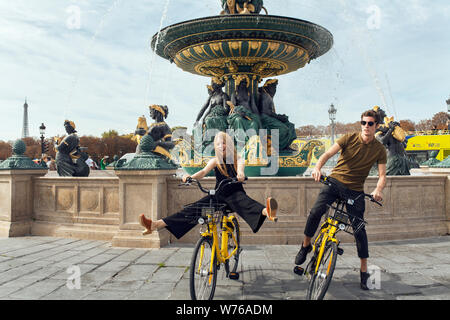 Die Einheimischen fahren Fahrräder der Chinesischen bike-sharing Service ofo vor dem Brunnen des Flusses Handel und Navigation in Paris, Frankreich, 6. Dezember Stockfoto