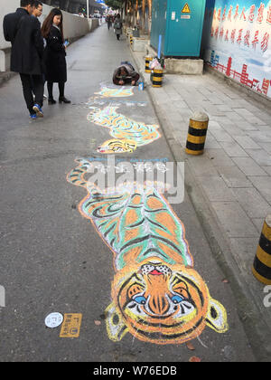 Ein deaktiviertes Chinesischer Mann zeichnet ein Leben - wie Tiger auf einem Bürgersteig in Wuhan City, Central China Provinz Hubei, 26. November 2017. Ein deaktiviertes Chines Stockfoto