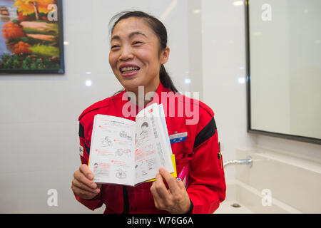Japanische Reinigung Arbeitnehmer Haruko Niitsu zeigt eins Ihrer Bücher über Reinigung einer Toilette im Shenzhen Bahnhof Nord in Shenzhen City, South Chi Stockfoto