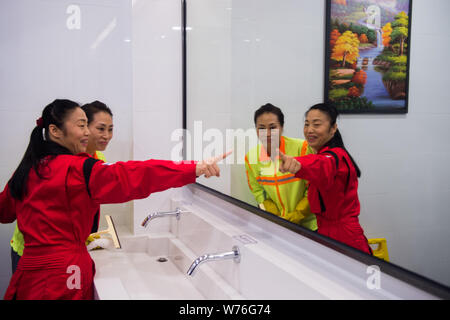 Japanische Reinigung Arbeitnehmer Haruko Niitsu, front, lehrt eine chinesische Reiniger in eine Toilette an der Shenzhen Bahnhof Nord in Shenzhen City, South China Stockfoto
