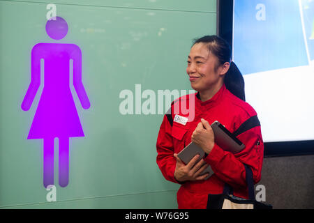 Japanische Reinigung Arbeitnehmer Haruko Niitsu stellt in einem Interview in einer Toilette im Shenzhen Bahnhof Nord in Shenzhen City, South China Guangdo Stockfoto