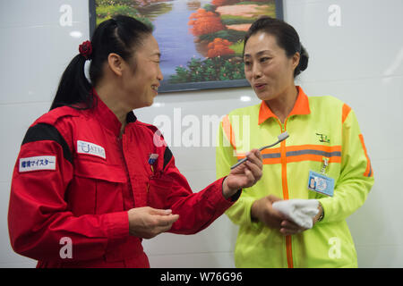 Japanische Reinigung Arbeitnehmer Haruko Niitsu, Links, lehrt eine chinesische Reiniger in eine Toilette an der Shenzhen Bahnhof Nord in Shenzhen City, South China Stockfoto