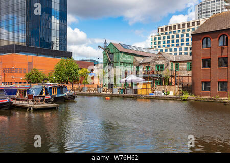 Ein Blick über die Canal Street Basin auf der Neuen Mainline Kanal in Richtung Canal House Pub mit Trinker auf dem Balkon und schmalen Boote, Birmingham, Großbritannien Stockfoto