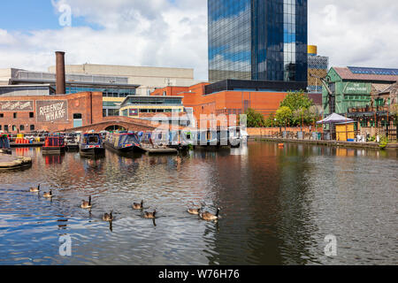 Ein Blick über die Canal Street Basin auf der Neuen Mainline Kanal in Richtung Canal House Pub mit Trinker auf dem Balkon und schmalen Boote, Birmingham, Großbritannien Stockfoto