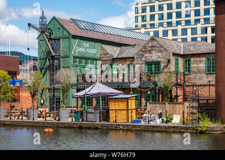 Ein Blick über die Canal Street Basin auf der Neuen Mainline Kanal in Richtung Canal House Pub mit Trinker auf dem Balkon und schmalen Boote, Birmingham, Großbritannien Stockfoto