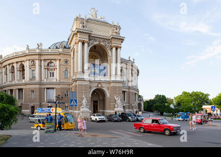 Ukraine, Odessa, Lanzheronivska Straße, vom 11. Juni 2019. Vorderansicht des Theater für Oper und Ballett mit einem roten Auto und Touristen sightseeing tour Buse Stockfoto