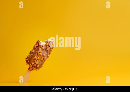Schokoladeneis popsicle auf gelbem Grund gebissen ein Stück Stockfoto