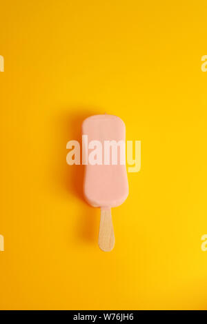 Rosa Eis popsicle auf gelbem Hintergrund, Ansicht von oben Stockfoto