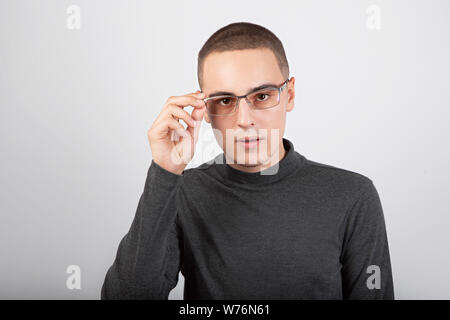 Clevere Unternehmen junger Mann in die Kamera schauen in Mode Gläser in casual cloting auf blauem Hintergrund. Closeup portriat Stockfoto