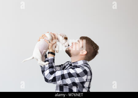 Menschen- und PET-Konzept - Nahaufnahme Portrait von Jack Russell Terrier Welpen sitzen auf die Hände des Menschen Stockfoto