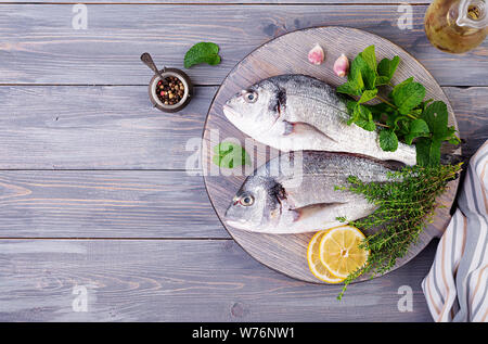 Raw dorado Fisch mit grünen Kräutern kochen auf Schneidebrett. Ansicht von oben Stockfoto