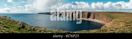 Panoramablick auf Thirle Tür und die Stapel von Duncansby neben den steilen Klippen und Kiesstrand in Duncansby Head in Schottland Stockfoto