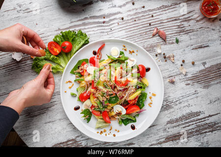 Salat aus Wachteleiern, Bohnen in Schoten, Tomaten, Zwiebeln Stockfoto