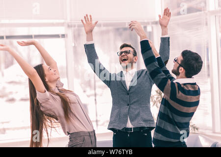 Konzept der Sieg - die jubelnde Business Team im Kreis stehend, Hände oben in Freude Erfolg. Stockfoto