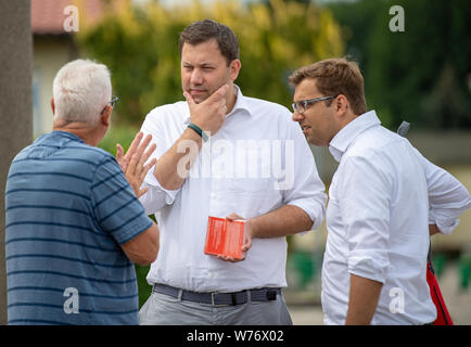 05.August 2019, Brandenburg, Jüterbog: Lars Klingbeil (M), SPD-Generalsekretär, und Erik Stohn (r), Brandenburgs SPD-Generalsekretär, sprechen mit dem ehemaligen Bürgermeister von Jüterbog Bernd Rüdiger bei einer Pressekonferenz auf der Tür-zu-Tür Wahlkampf in der werderschen Siedlung. Foto: Monika Skolimowska/dpa-Zentralbild/dpa Stockfoto