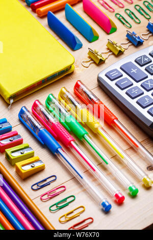 Gruppe von Schulmaterial und Notebooks auf hölzernen Tisch Stockfoto