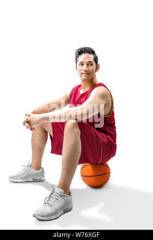 Asiatischer mann Basketballspieler auf dem Ball isoliert auf weißem Hintergrund Stockfoto