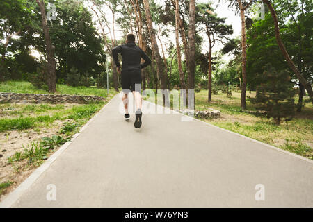 Junge sportliche Mann in bewaldeten Park Stockfoto