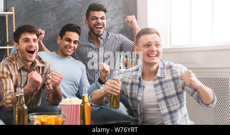 Freundliche männliche Freunde feiern den Sieg ihrer Lieblingsmannschaft Stockfoto