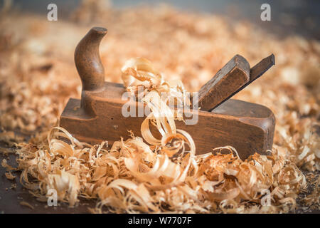 Alte hölzerne Hand Ebene für die Holzbearbeitung mit Holzwolle. Stockfoto