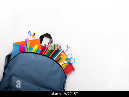 Schule Rucksack mit farbigen Schreibwaren auf weißem Hintergrund Stockfoto