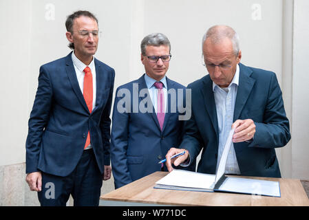 München, Deutschland. 05 Aug, 2019. Frank Matthias Kammel (L-R), Generaldirektor des Bayerischen Nationalmuseums, Bernd Sibler (CSU), Bayerischer Staatsminister für Wissenschaft und Kunst und Hardy Langer, Vertreter der Erbengemeinschaft, Zeichen der Restitution der Vereinbarung. Fünf Gemälde, drei Farbe Gravuren und eine hölzerne Verkleidung wurde durch die Gestapo im November 1938 beschlagnahmt. Die Münchner Sammlungen haben nun die Werke an die Erben von Julius und Simone Davidsohn aus München zurück. Credit: Sina Schuldt/dpa/Alamy leben Nachrichten Stockfoto
