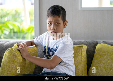 Khaoak, Thailand, 20. Juli 2019: Asiatische junge Mann auf dem Sofa sitzen. Besorgten, besorgt. Stockfoto
