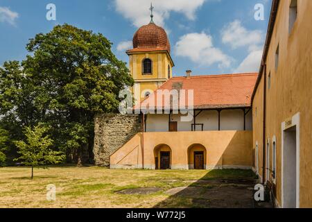 Panensky Tynec, Tschechische Republik - 15. Juli 2019: Gelb Glockenturm und ehemaliges Kloster der Klarissen, heute der Stadtverwaltung. Sonnigen Tag. Stockfoto