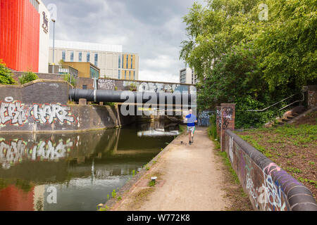 Birmingham City University rote und weiße Gebäude auf Curzon Street im Sommer Licht gegen dunkle Wolken hit Macht dramatische Ausblicke auf den Digbeth Branch Canal, Stockfoto