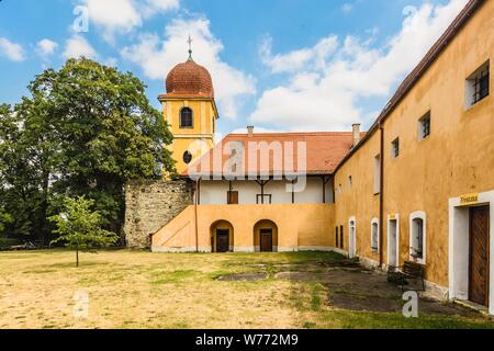 Panensky Tynec, Tschechische Republik - 15. Juli 2019: Gelb Glockenturm und ehemaliges Kloster der Klarissen, heute der Stadtverwaltung. Sonnigen Tag. Stockfoto