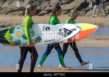 Teenage Surfer ihre Surfbretter und zu Fuß aus dem Meer auf den Fistral Beach in Newquay in Cornwall. Stockfoto