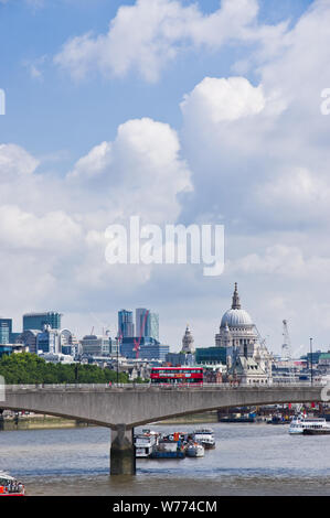 Eine rote London Bus kreuze Waterloo Bridge über die Themse, mit St Pauls Kathedrale am Horizont sichtbar. Stockfoto