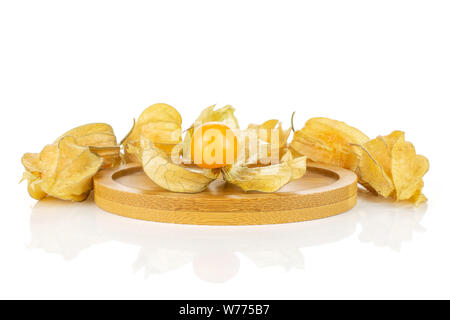 Menge ganze Frische orange Physalis auf runden Bambus Untersetzer auf weißem Hintergrund Stockfoto
