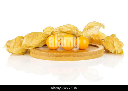Menge ganze Frische orange Physalis auf runden Bambus Untersetzer auf weißem Hintergrund Stockfoto