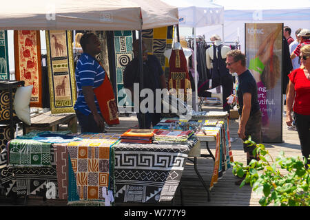 Shopper's auf der Suche nach Afrikanischen ausgelegt Teppiche zu einem Handwerk Messe. New Westminster, British Columbia, Kanada. Stockfoto