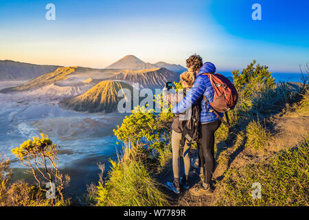 Junges Paar, Mann und Frau treffen, um den Sonnenaufgang am Bromo Tengger Semeru National Park auf der Insel Java, Indonesien. Sie genießen einen herrlichen Blick auf Stockfoto