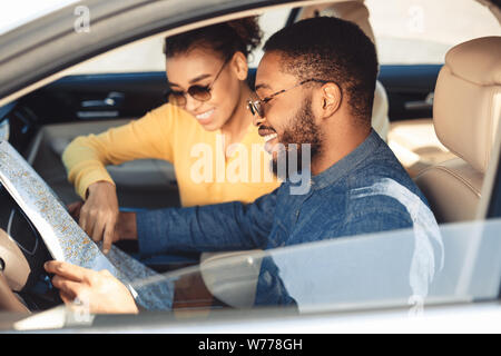 Gerne schwarz Paar an der Karte im Auto suchen Stockfoto