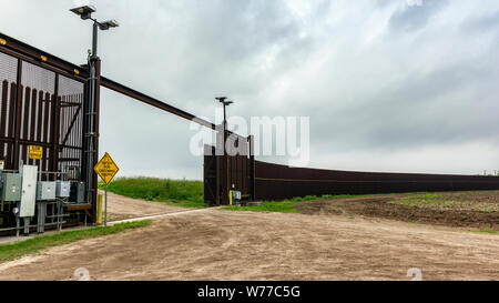 Ein Teil der Stahl Grenzzaun mit einem Tor, Brownsville, Texas, USA Stockfoto