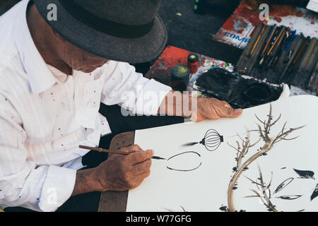 Hoi An, Vietnam - Juni 2019: street artist Malerei Traditionelle Laternen auf Papier Stockfoto