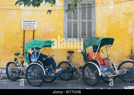 Hoi An, Vietnam - Juni 2019: Vietnamesische Rikscha in seinem Fahrrad Warenkorb schlafen auf der Straße Stockfoto