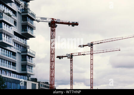 Red baukräne vor weißen Himmel bauen hohe Wohngebäude. Stockfoto